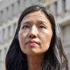 Michelle Wu looks up as she stands outside the City Hall building.