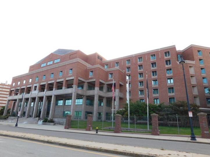 A large brick courthouse abuts a road.