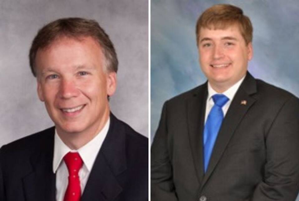 Two men wearings suits and ties smile for professional portraits.