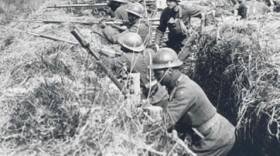Soldiers of the 369th Infantry practice in France during World War I. They are wearing French "Adrian" helmets and using French issued rifles and equipment.