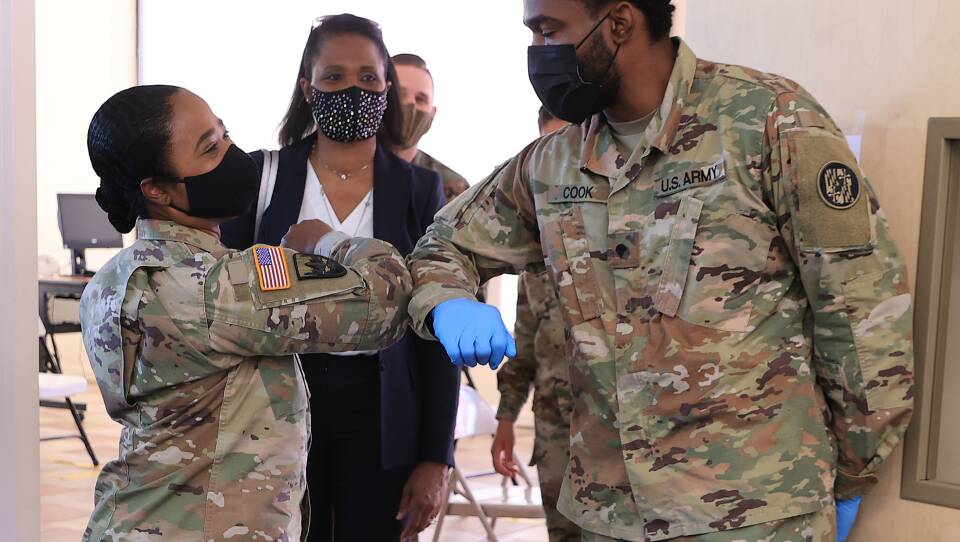 Nearly 130 million U.S. adults have completed their vaccine regimens, the CDC says, with another 70 million vaccine doses currently in the distribution pipeline. Here, Maryland National Guard Brig. Gen. Janeen Birckhead greets soldiers last week at a mobile vaccine clinic in Wheaton, Md.