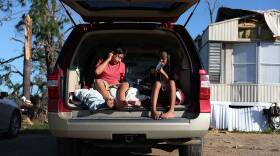 Carlos and Jessica Deviana sit in the back of their father's SUV, which they were using as a bedroom after Hurricane Michael destroyed their home in Panama City, Fla., in October 2018.