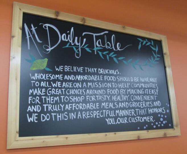 The mission of Daily Table, written on a chalk board hanging on the wall.