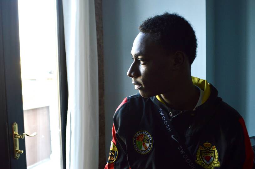 A young man gazes out of a window