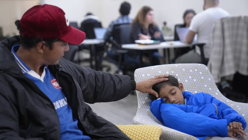 A man strokes his son's hair in a waiting room.