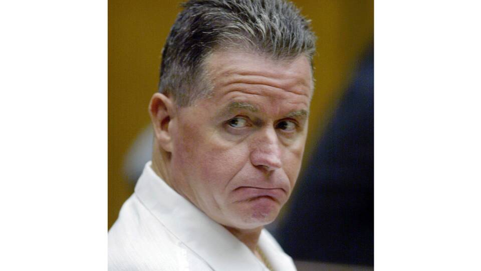 A closeup of a man frowning in a courtroom.
