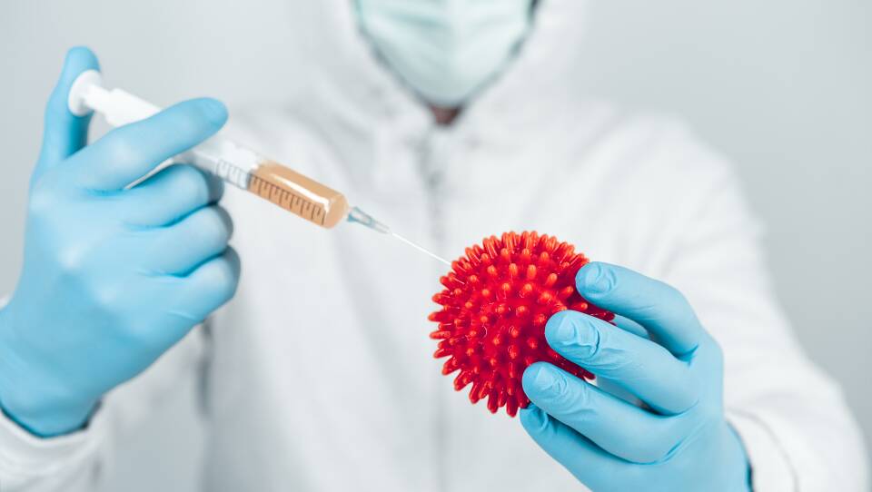 Close-Up Of Gloved Hands Holding Syringe And Virus Representation
