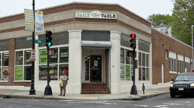 Store front from across an intersection with sign on building that reads Daily Table.