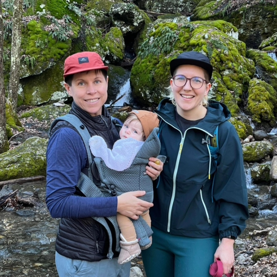 Two women are on a hike, one carrying a baby