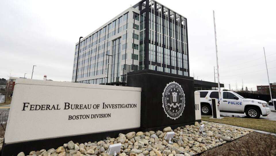 A blocky building has a sign out front: "Federal Bureau of Investigation: Boston Division." A Homeland Security car is parked outside.
