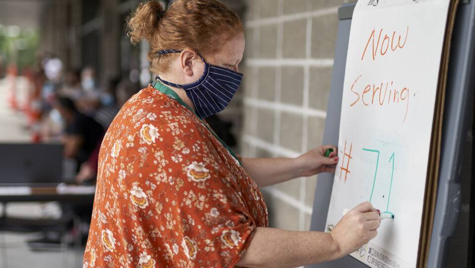 Vickie Gregorio with Heartland Workforce Solutions in Omaha, Neb., updates a whiteboard outside the workforce office as unemployed job seekers wait in line for help. A recent change in federal rules gives some people who have lost their health plan along with their job more than the usual 60 days to sign up for COBRA health coverage.