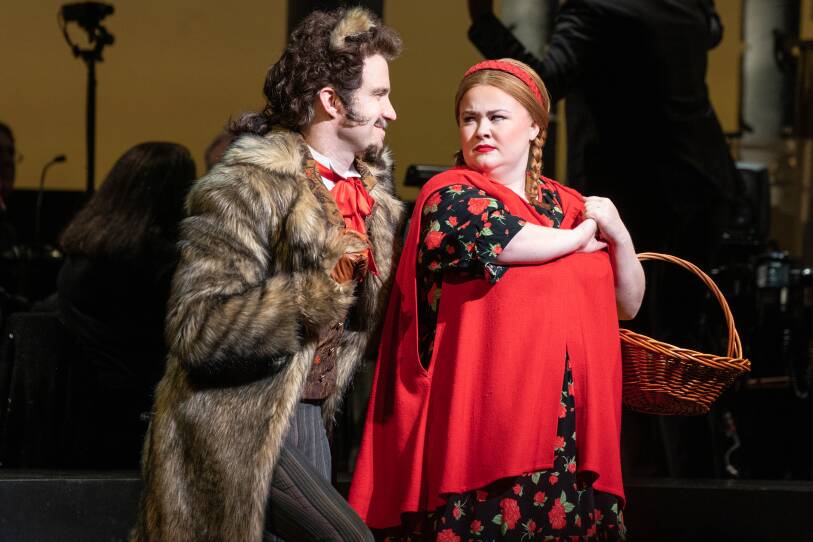 An actor dressed as a wolf and an actor playing Little Red Riding Hood look at each other during a performance of "Into the Woods"