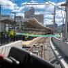 A photo taken from the perspective of a trolley driver, showing a train approaching a platform full of people with a ribbon stretched across it.