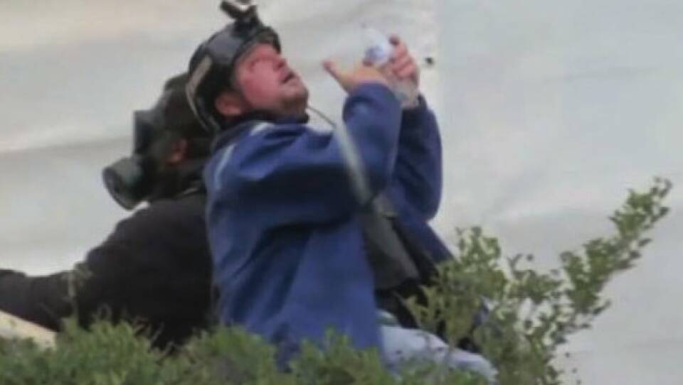 The U.S. government says in its affidavit that this photo shows Guy Reffitt rinsing his eyes outside the Capitol on Jan. 6, 2021, wearing a blue jacket over a tactical vest and a helmet with a camera.