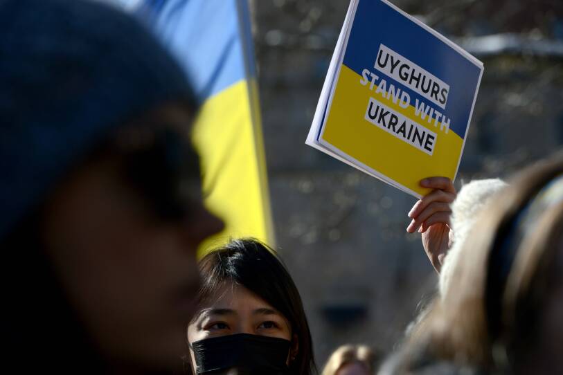 Woman wearing a mask holding up sign.