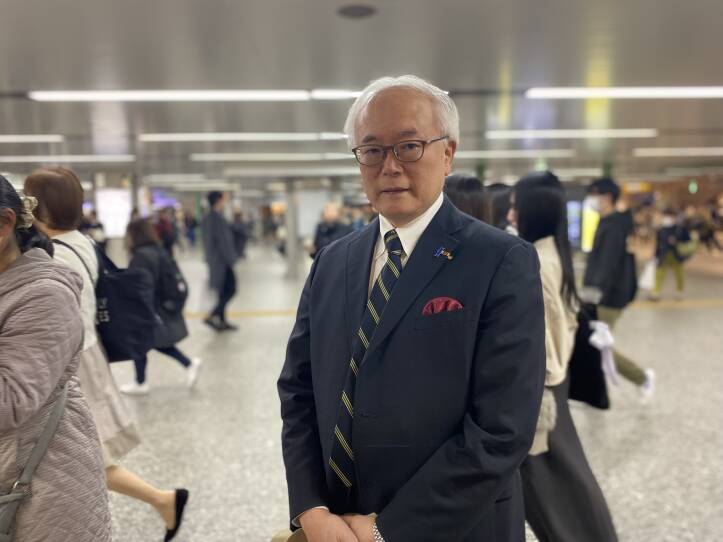 A man stands in a crowded train station