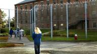 Incarcerated women walk from a courtyard back toward the Framingham prison.
