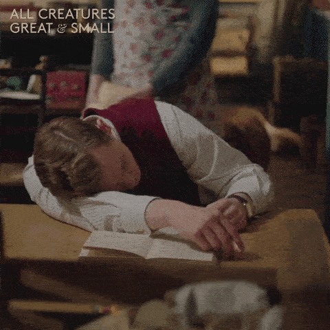 A napping young man is woken up by a woman bonking him on the head