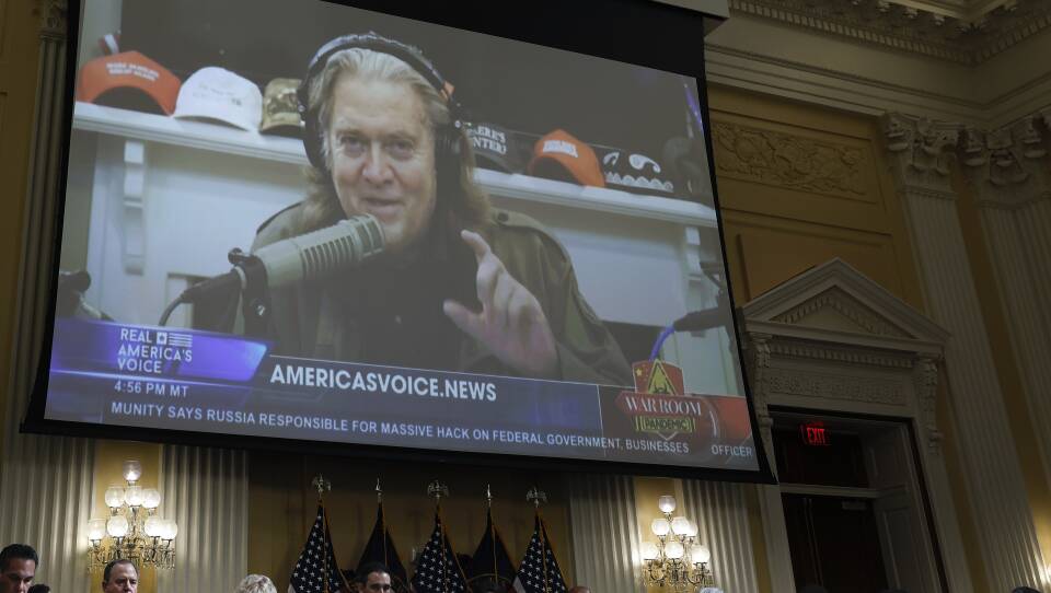Steve Bannon, who was chief strategist for former President Donald Trump, appears on a video screen above members of the House committee that's investigating the Jan. 6, 2021, attack on the U.S. Capitol, during a hearing on July 12.