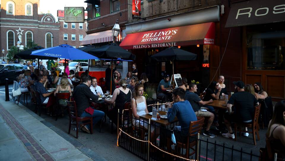 Tables of patrons are dining outdoors in the North End, outside of Pellino’s Ristorante
