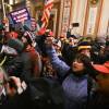 A mob breached security and stormed inside the U.S. Capitol on Jan. 6. The woman in blue with her fist raised was later identified as Suzanne Ianni.