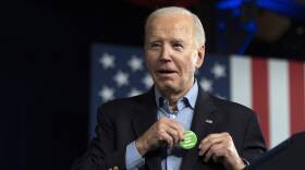 President Joe Biden puts on a button that was thrown to him from the crowd that says "Regulate Guns NOT Women" as he speaks at a campaign rally Saturday, March 9, 2024, at Pullman Yards in Atlanta.
