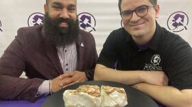 Dan Newman, left, the founder of Alaska Premier Auctions and Appraisals, and Nick Cline, a business partner, pose Friday in Anchorage with the "Americus Australis," thought to be one the largest gem-quality opals in existence.