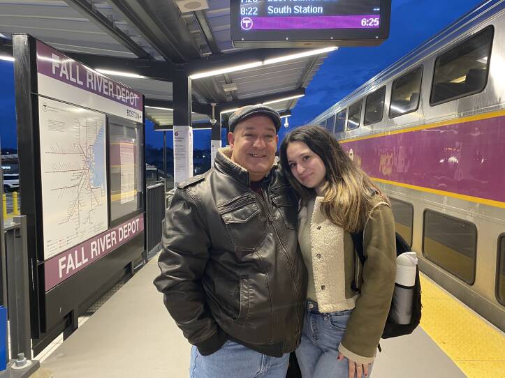 A man and a woman stand outside of a train