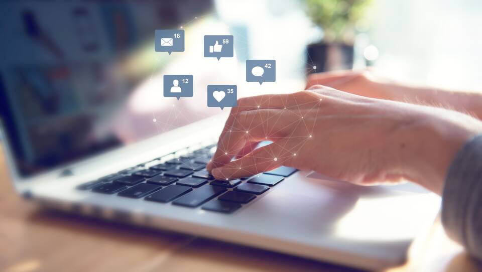 Businesswoman hands using laptop with icon social media and social network.