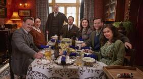Shown from left to right: Tristan Farnon (Callum Woodhouse), Mrs. Hall (Anna Madeley), Richard Alderson (Tony Pitts), Siegfried Farnon (Samuel West), Jenny Alderson (Imogen Clawson) James Herriot (Nicholas Ralph), Helen Herriot (Rachel Shenton)