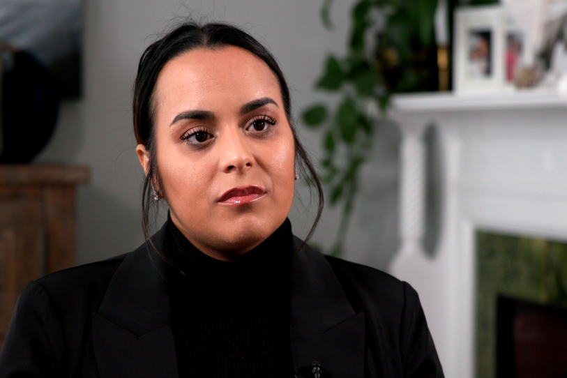 A woman in a black turtleneck, seated for a filmed interview