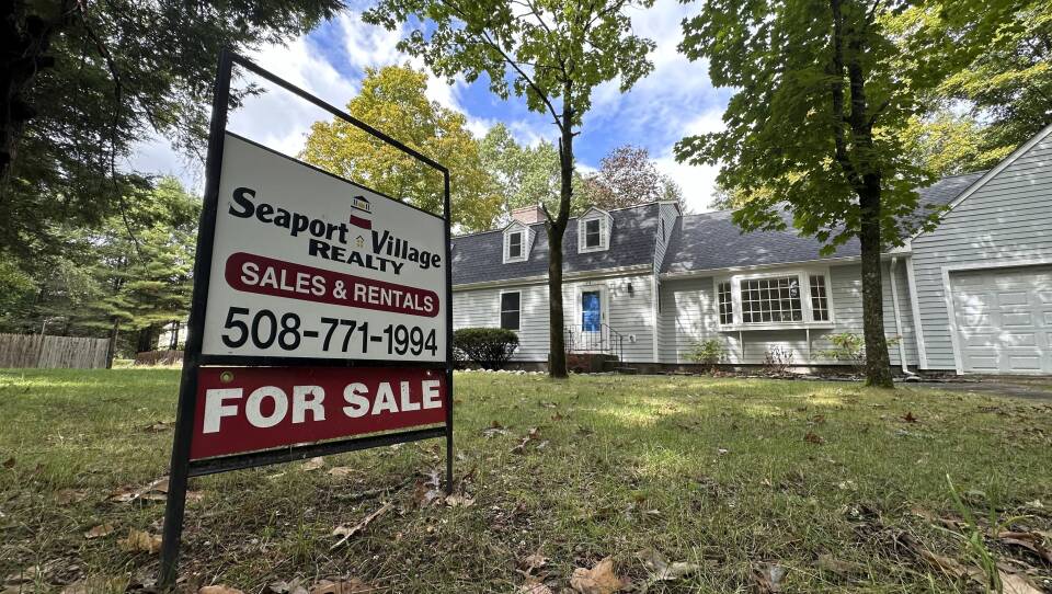 A sign in front of a single-family home reading seaport village realty sales and rentals -- for sale.