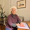 A lady sits at a desk.