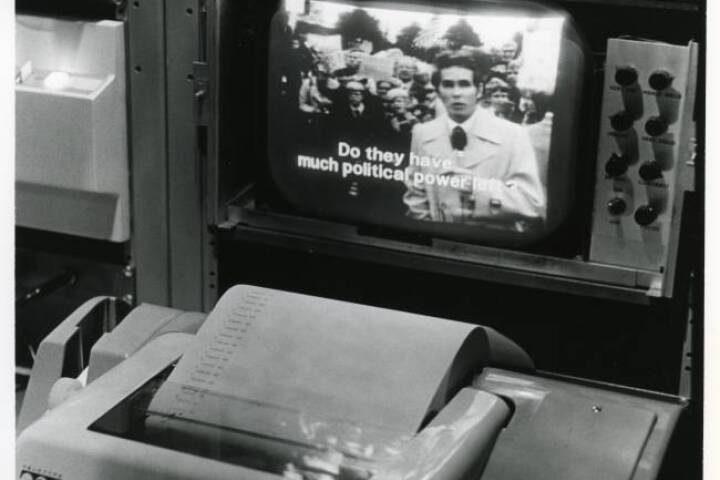 1971 A black and white photo shows a caption writer typing on a specialized typewriter.