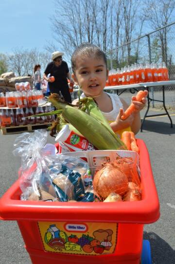 A young participant helps select fresh produce at a Mobile Market, a farmer's market-style program of GBFB.