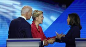 Warren and Harris shake hands on the debate stage, both wearing blazers after finishing the televised event.