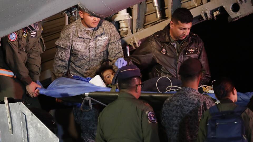 On Saturday in Bogota, Colombia, military personnel unload from a plane one of four Indigenous children who were missing after a deadly plane crash.