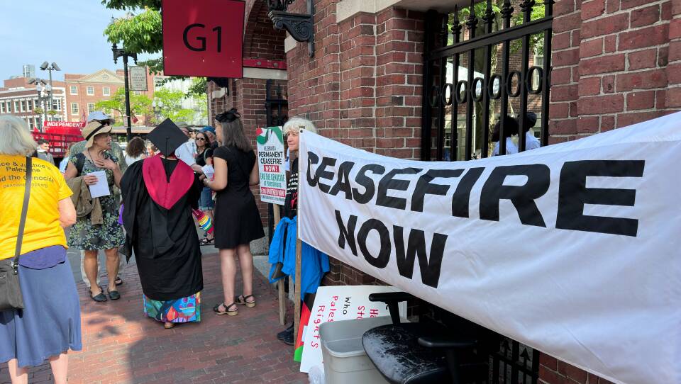 Protestors hold a banner with the words ceasefire now.