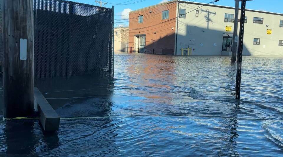 Water covers an intersection and staircases to buildings.