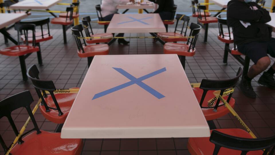 Tables are marked with X's for social distancing in the outdoor dining area of a restaurant in Los Angeles, Wednesday. California Gov. Gavin Newsom has ordered a three-week closure of bars and indoor operations of restaurants and certain other businesses in Los Angeles and 18 other counties as the state copes with increasing cases of COVID-19.