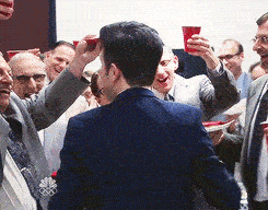 A man looks over his shoulder, smiles, and winks