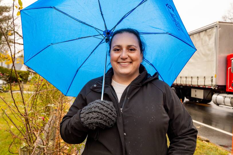 Beverly teacher Amelia Arbeely on strike and standing under a blue umbrella