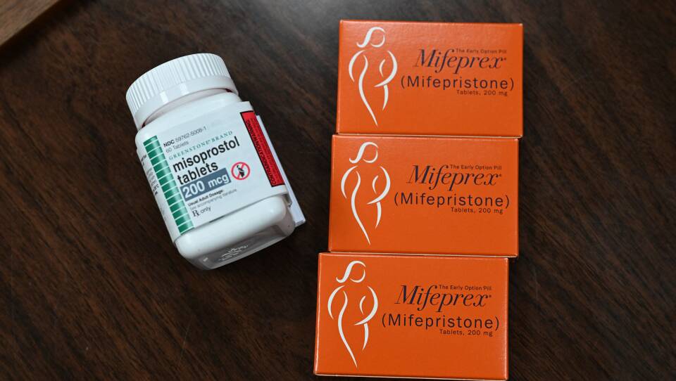 A bottle of pills sits next to boxes of other pills.