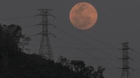A full moon rises behind the high voltage towers of the El Avila in Caracas, Venezuela, Sunday, May 15. People in the Americas, Europe and Africa had a chance to see the total lunar eclipse that began Sunday night.