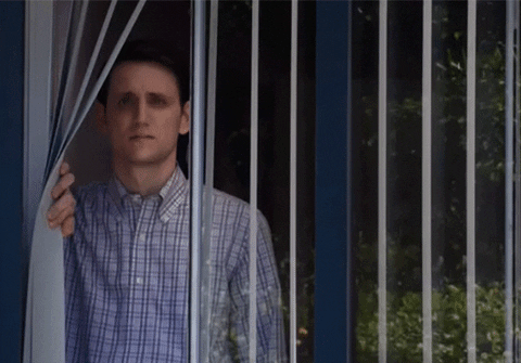 A man stares out a window, full of melancholy