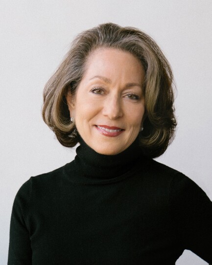 A woman wearing a black turtleneck sweater smiles in a formal portrait.