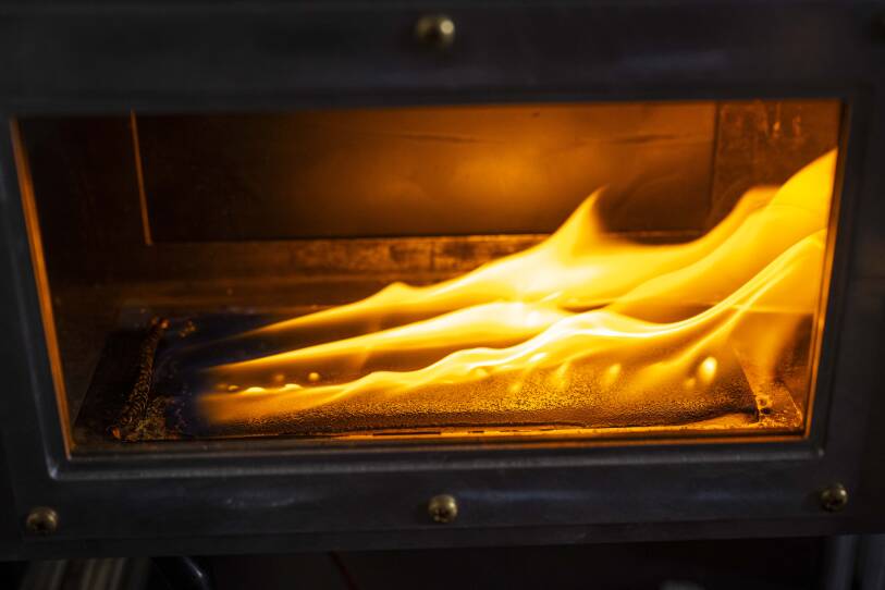 A flame inside a metal and clear box.