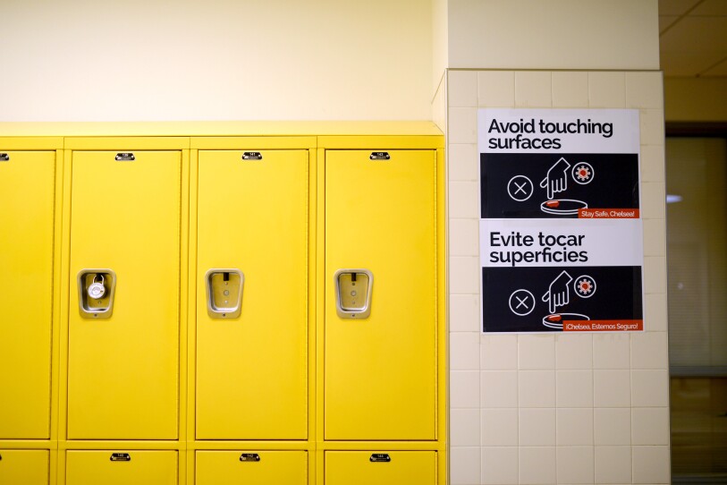 Yellow student lockers with a sign asking students to not touch surfaces