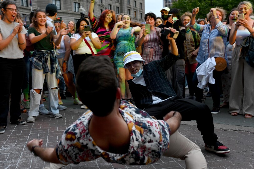 Two men dance low to the ground.