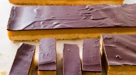 Rectangular slices of layered cookie bars — shortbread, a toffee-colored layer, and chocolate on top